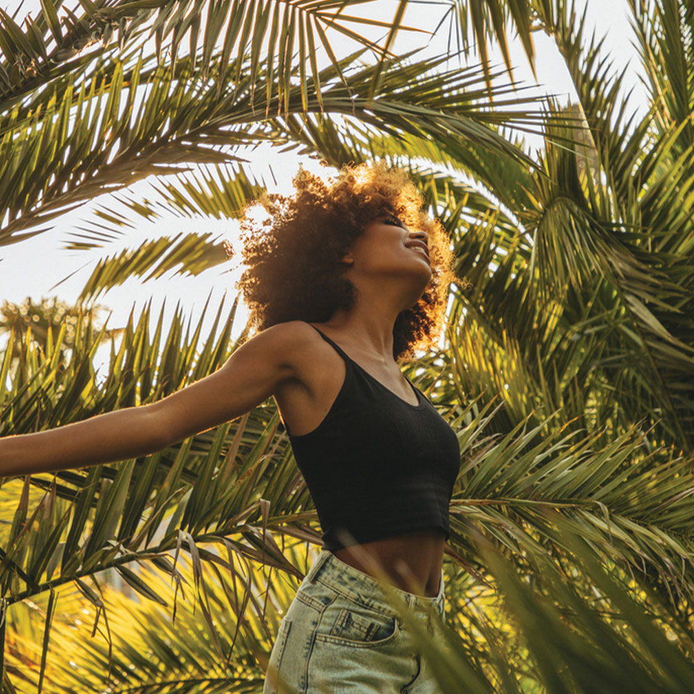 a person standing next to a palm tree